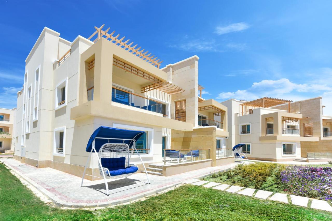 Tolip Resort El Galala Majestic Ain Suchna Exterior foto The photo displays a modern residential complex featuring two or more white buildings with a contemporary architectural design. Each building has balconies, large windows, and a sunshine-friendly layout that maximizes natural light. In the foreground