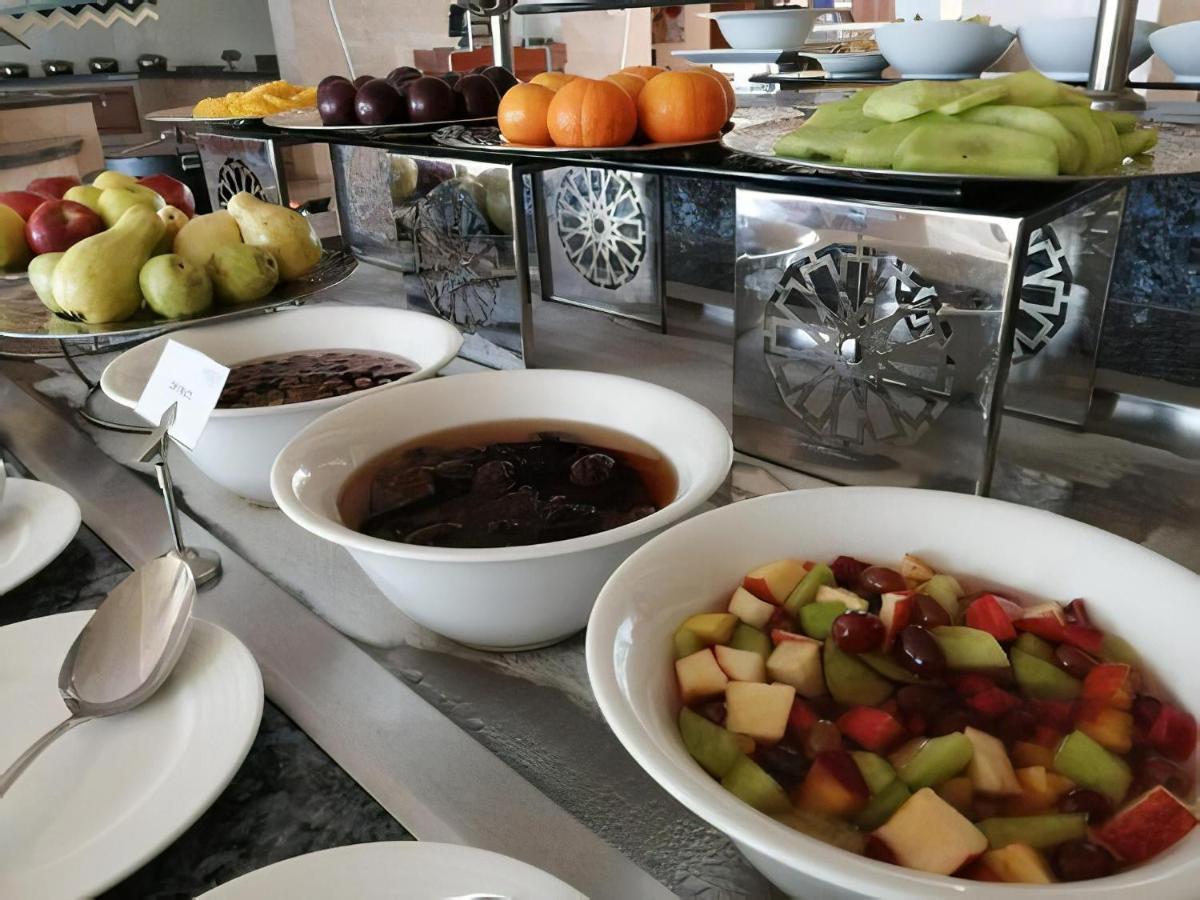 Tolip Resort El Galala Majestic Ain Suchna Exterior foto The photo shows a buffet-style arrangement of various fruits and fruit dishes. In the foreground, there are several bowls containing different types of fruit. One bowl has a fruit salad made with diced apples, green apples, and possibly other fruits.